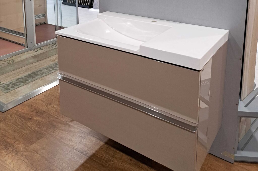 Lavabo suspendido de estilo moderno con mueble acabado en tono visón con dos amplios cajones y tiradores de aluminio integrados. Anchura: 90 cm, consúltanos para más información .