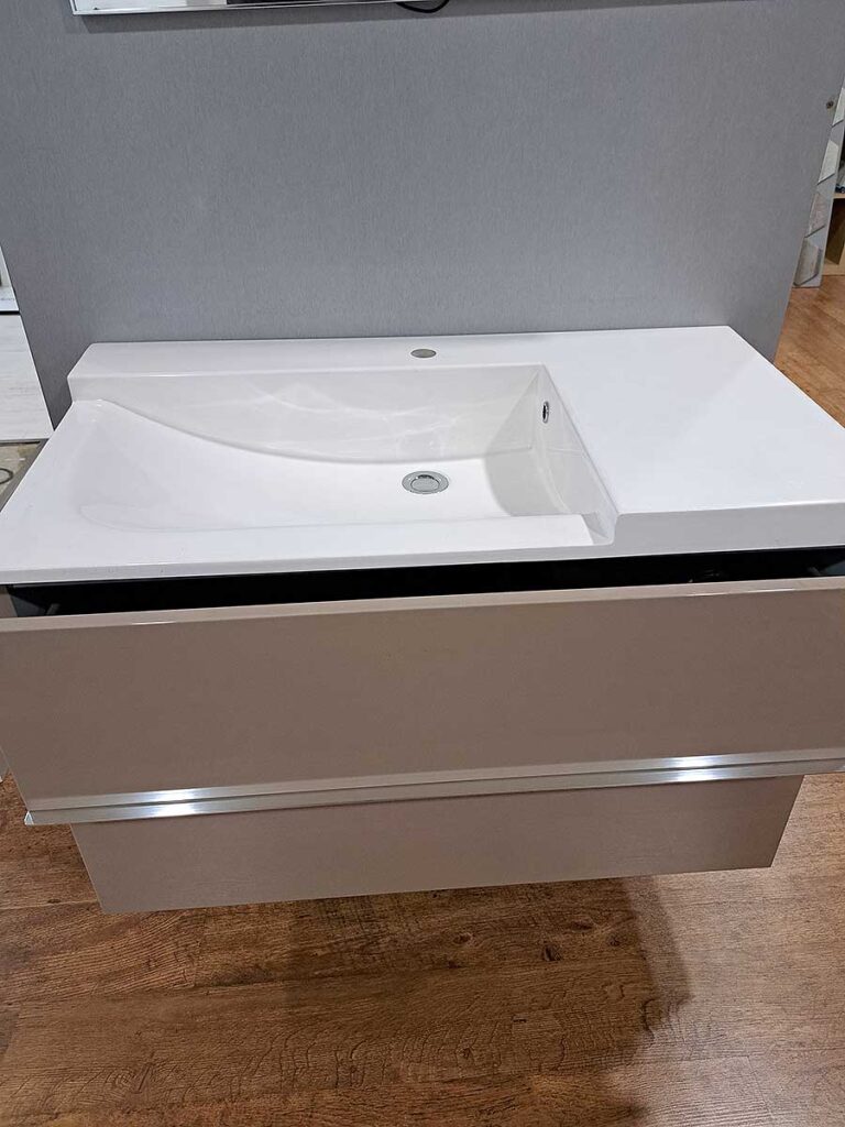 Lavabo suspendido de estilo moderno con mueble acabado en tono visón con dos amplios cajones y tiradores de aluminio integrados. Anchura: 90 cm, consúltanos para más información .